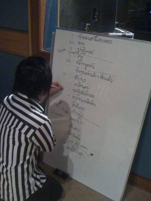 deeboyd-natty Natty กำลังเขียนคิวเพลง วิธีต่อเพลง และคีย์เพลงลงบน whiteboard ให้นักดนตรีดูระหว่างซ้อม