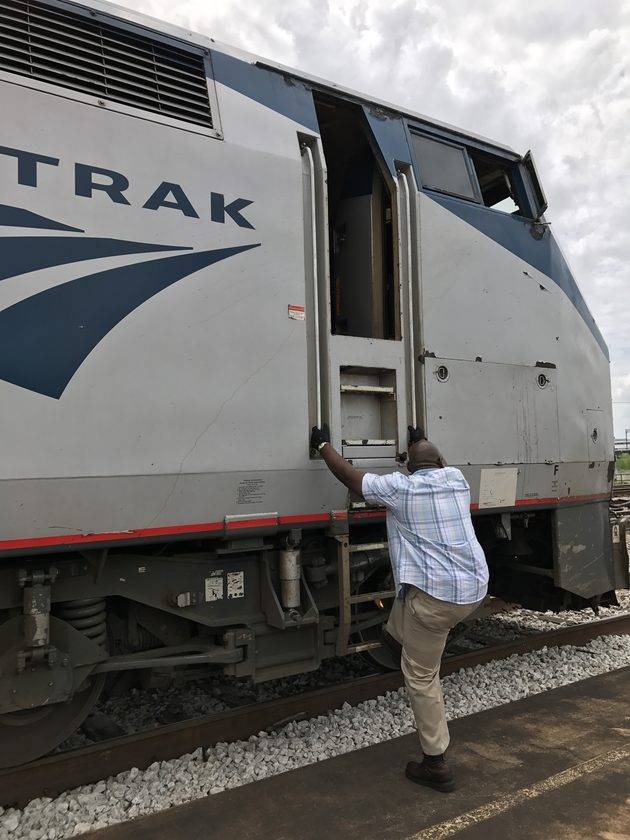คนขับรถไฟตัวใหญ่ ปีนขึ้นหัวรถจักร ซึ่งก็ใหญ่